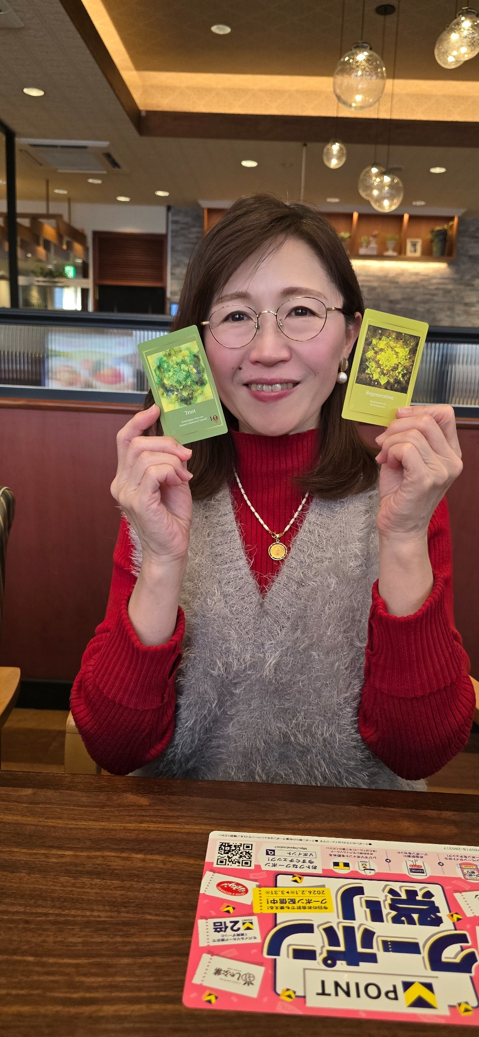 セッション後に２枚のカードを手にする女性のお客様